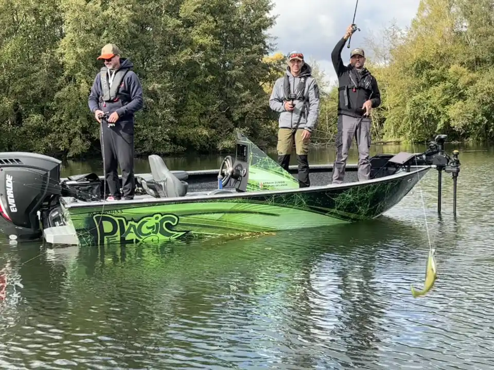 Trois pêcheurs sur un bassboat vert qui pêche aux leurres