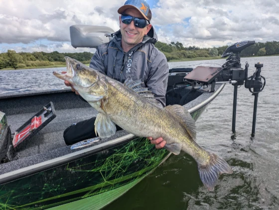 Moniteur guide de pêche avec un gros sandre et un sondeur en arrière plan