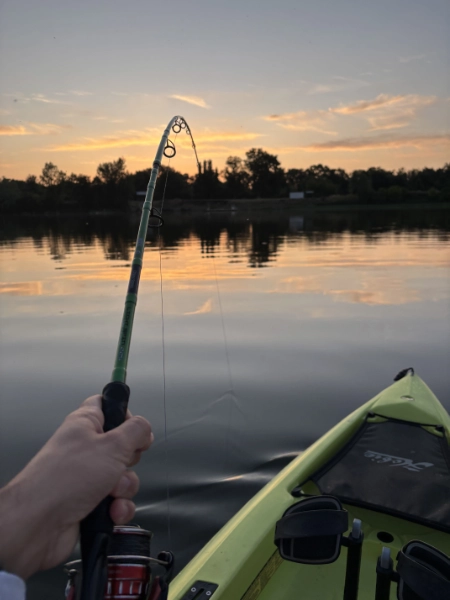 photo du combat d'un silure depuis un kayak lors d'un couché de soleil