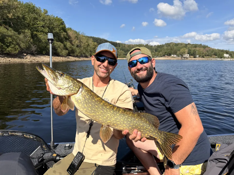 un pêcheur et son guide heureux d'avoir attraper un brochet
